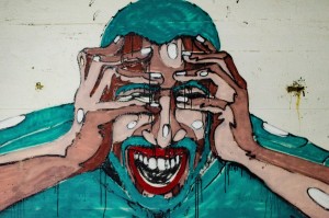 This is artwork by Aaron Blanco Tejedo of a man holding his face and crying out with eyes closed. He looks pained, stressed, anxious.r-