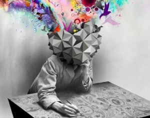 This black-and-white image of a young adult sitting at a flat desk that has been covered with doodles and drawings. The person's head is replaced with a 3D geometric shape, which has burst open and is releasing brightly colored streams, shapes and figures.